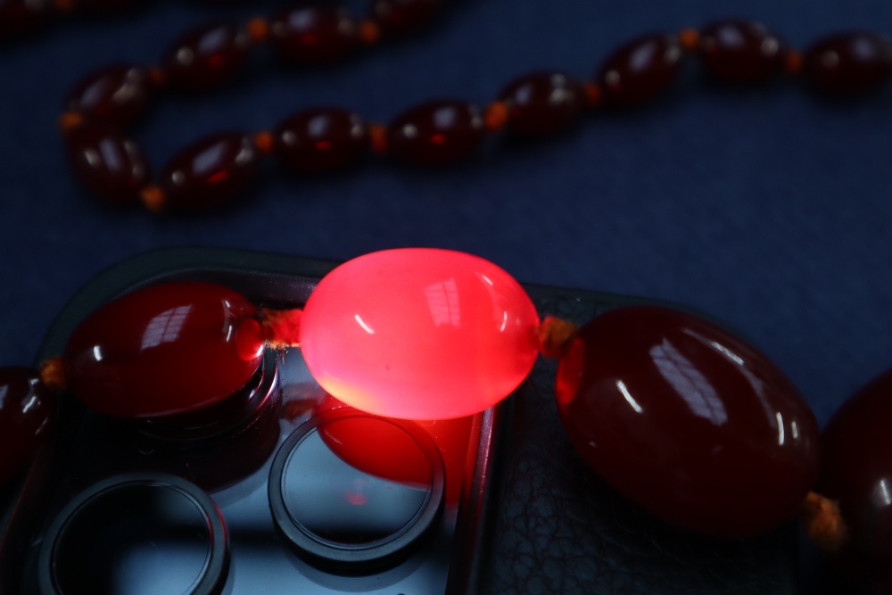 A cherry amber / bakelite beaded necklace, with graduating beads varying in size from 30mm to 10mm, - Image 8 of 9
