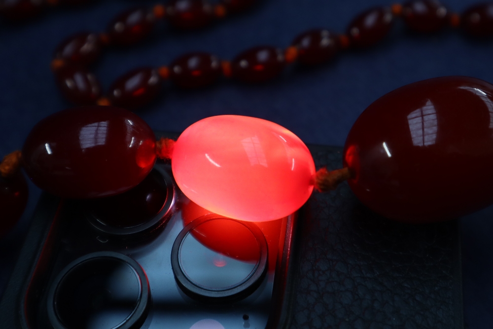 A cherry amber / bakelite beaded necklace, with graduating beads varying in size from 30mm to 10mm, - Image 7 of 9