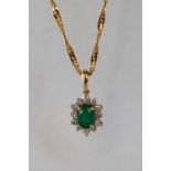 An emerald and diamond pendant set with a central emerald and twelve round brilliant cut diamonds