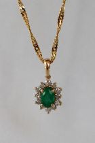 An emerald and diamond pendant set with a central emerald and twelve round brilliant cut diamonds