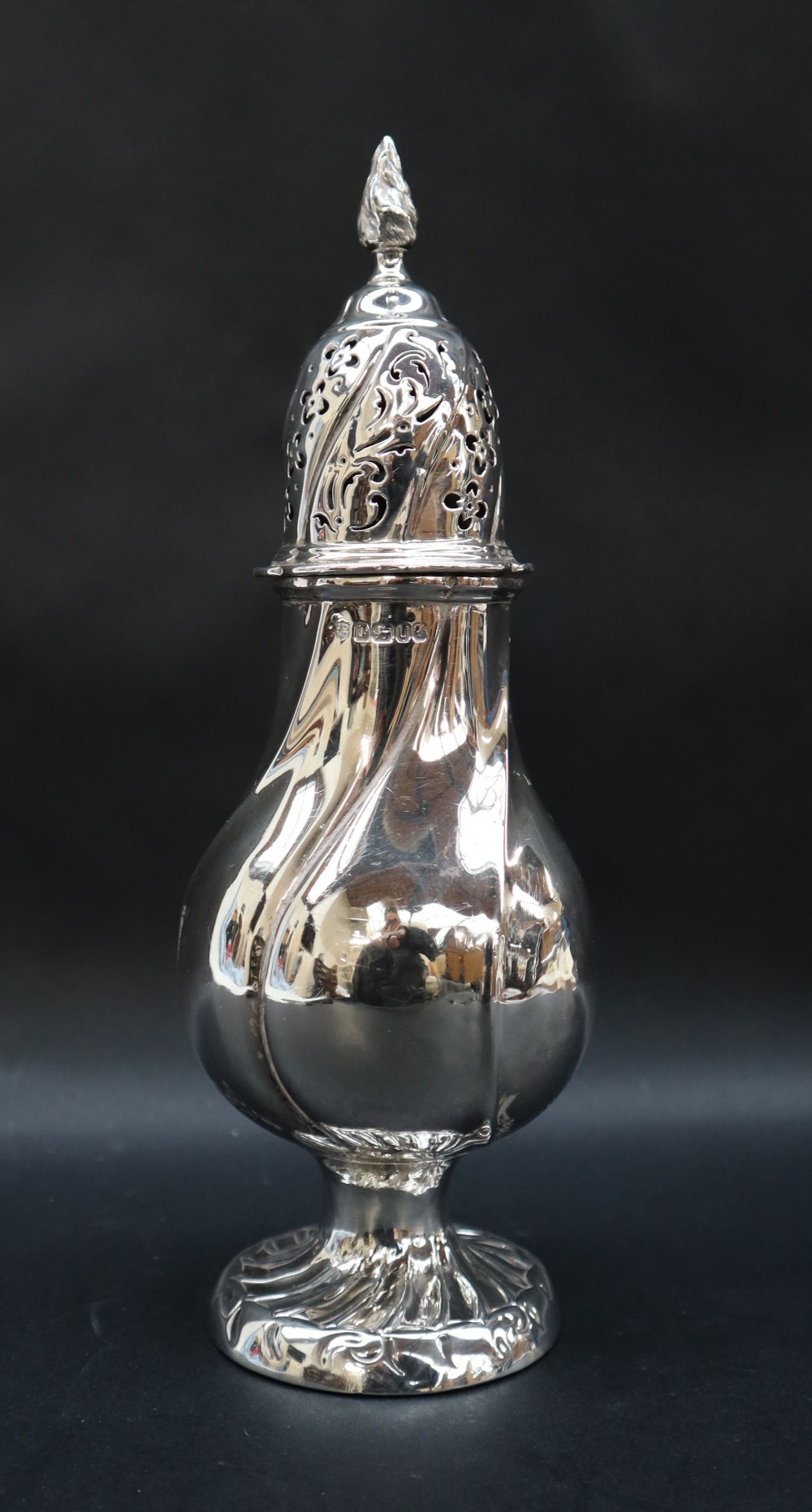 A Victorian silver sugar caster with a flaming finial and twisted domed pierced top and baluster