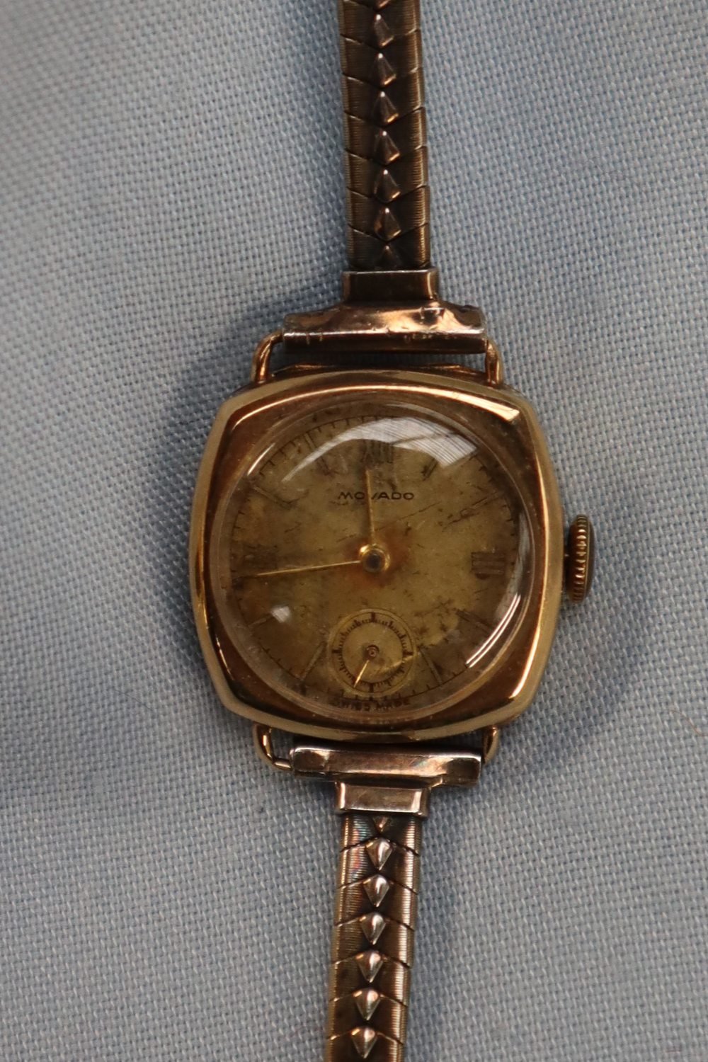 A lady's 9ct gold Movado wristwatch with a circular gilt dial and Roman numerals