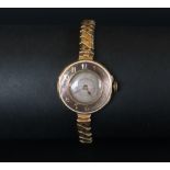 An 18ct gold lady's wristwatch the outer rim with Arabic numerals with a silvered dial,