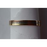 An 18ct three colour banded gold hinged bangle,