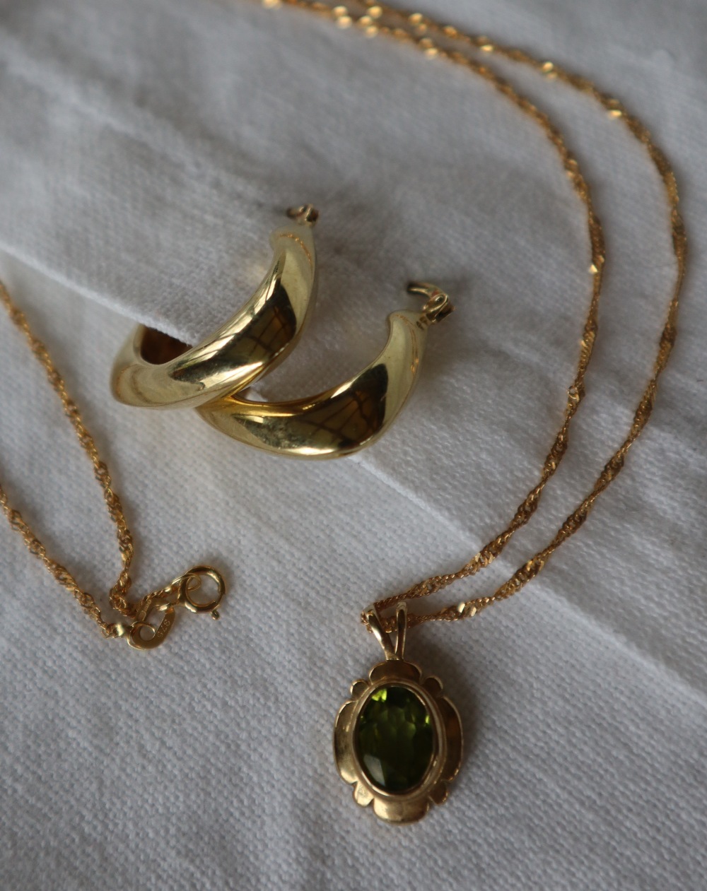 A pair of 9ct gold hoop earrings together with a 9ct gold peridot set pendant on a 9ct gold chain, - Image 3 of 4