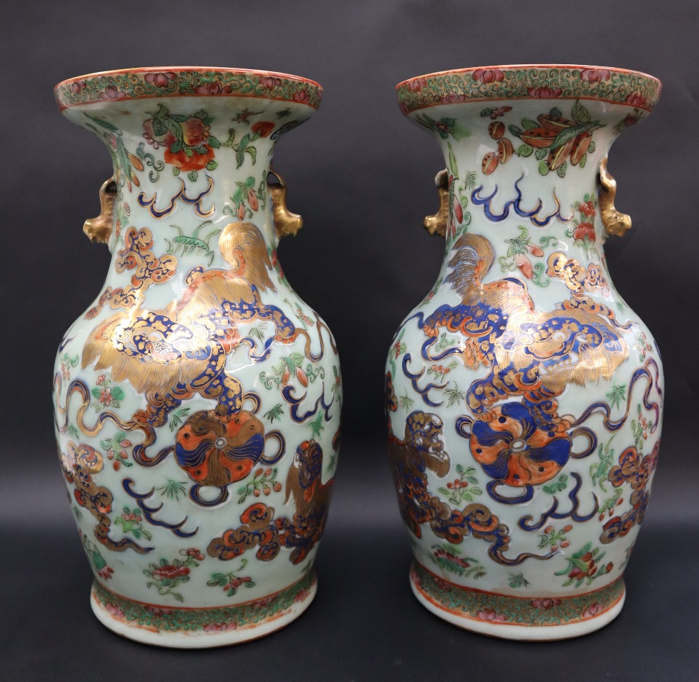 A pair of Cantonese porcelain vases, decorated with a lion dog and ball,