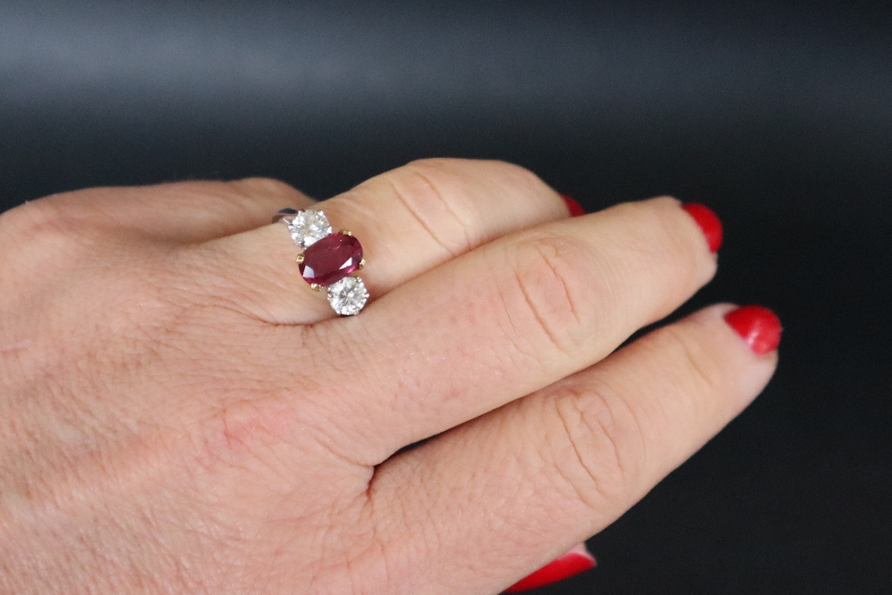 A ruby and diamond ring set with a central oval faceted ruby, approximately 9mm x 6mm, - Bild 8 aus 12