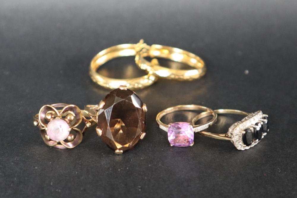 A 9ct yellow gold amethyst set dress ring together with two other 9ct gold rings another ring and