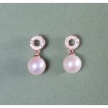 A pair of 9ct rose gold pearl and diamond halo bale earrings.