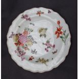A porcelain plate with a shaped edge, painted with sprays of garden flowers,