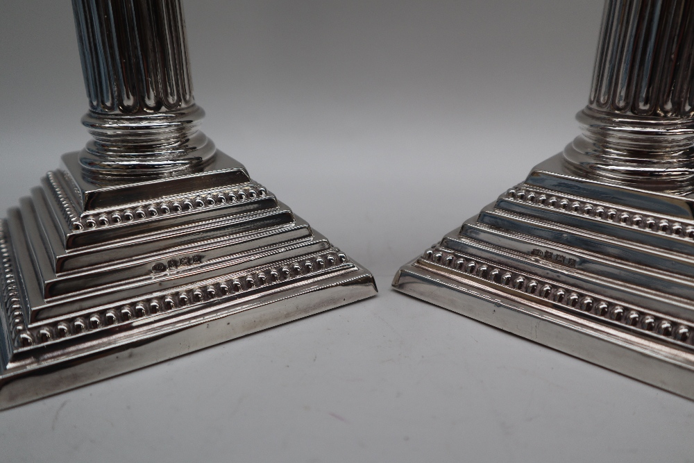 A pair of Elizabeth II silver corinthian column candlesticks with a stop fluted column and stepped - Image 2 of 4