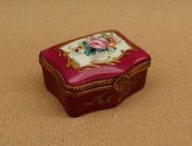 A 19th century porcelain box and cover painted with flowers to the lid and a rose pink border with