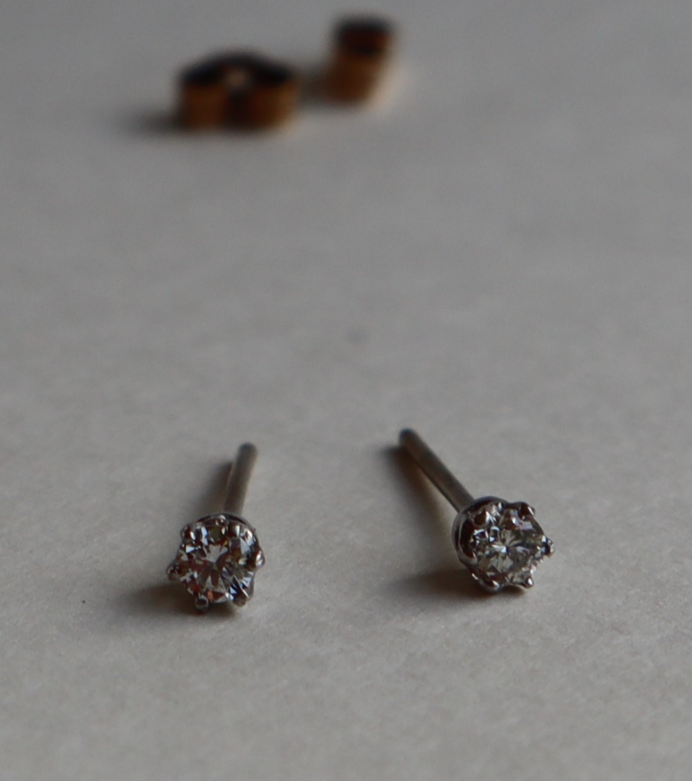 A pair of diamond stud earrings, each set with round brilliant cut diamonds, approximately 0.