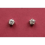 A pair of diamond solitaire stud earrings,