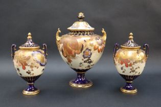 A Royal Crown Derby garniture of three vases with domed covers the body decorated with flower heads