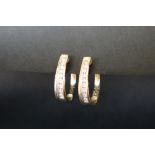 A pair of 14ct gold diamond set hoop earrings, with nine round brilliant cut diamonds, channel set,