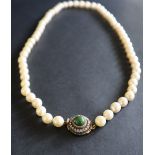 A pearl necklace set with fifty nine large regular pearls to a diamond and cabochon set yellow