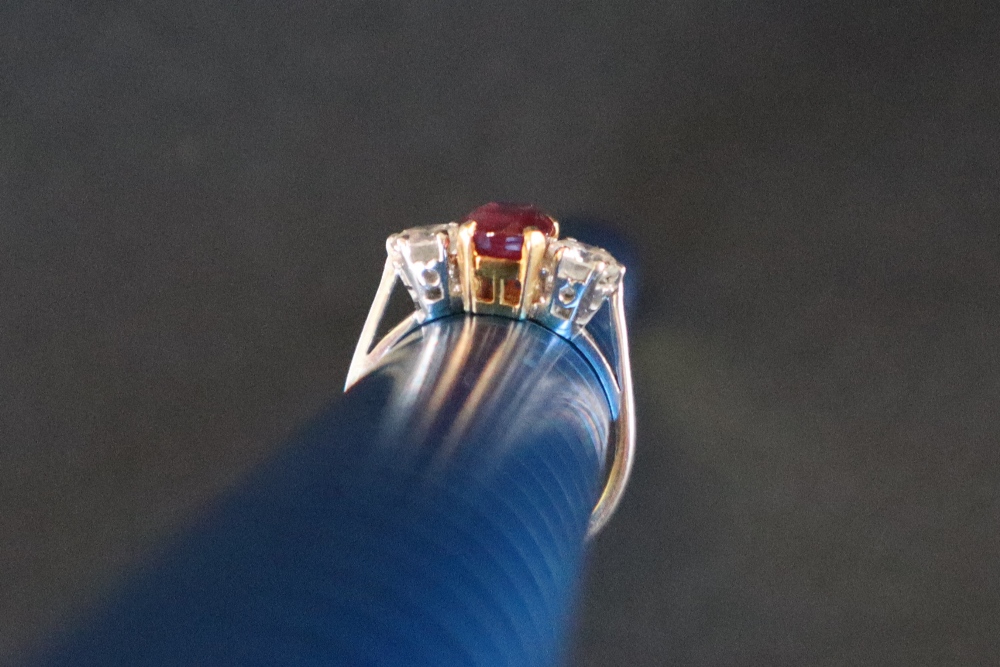 A ruby and diamond ring set with a central oval faceted ruby, approximately 9mm x 6mm, - Image 10 of 12