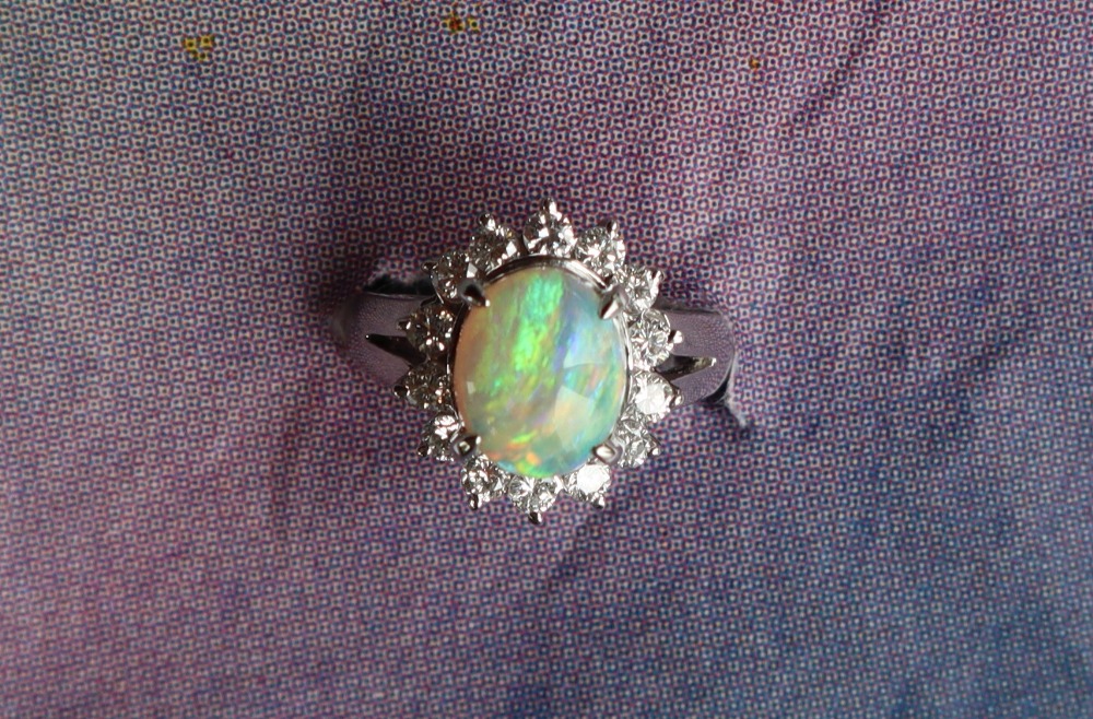 An opal and diamond ring set with a cabochon oval opal and a halo of round brilliant cut diamonds - Image 2 of 6