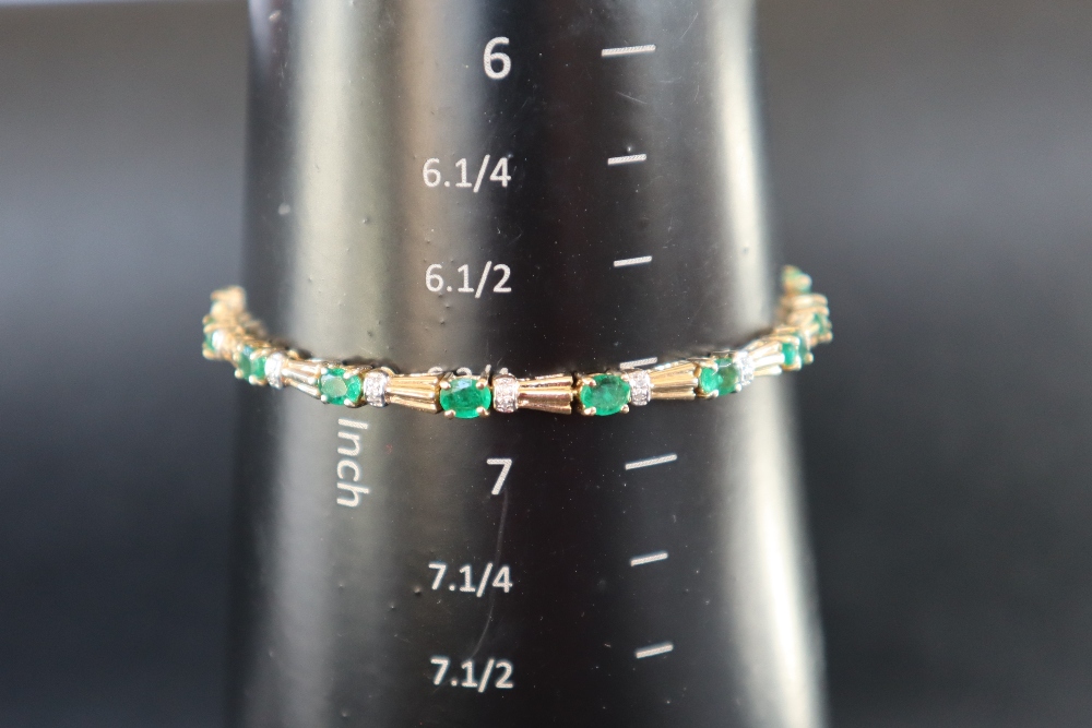 An emerald and diamond tennis bracelet set with sixteen oval faceted emeralds and diamonds to a - Image 4 of 6