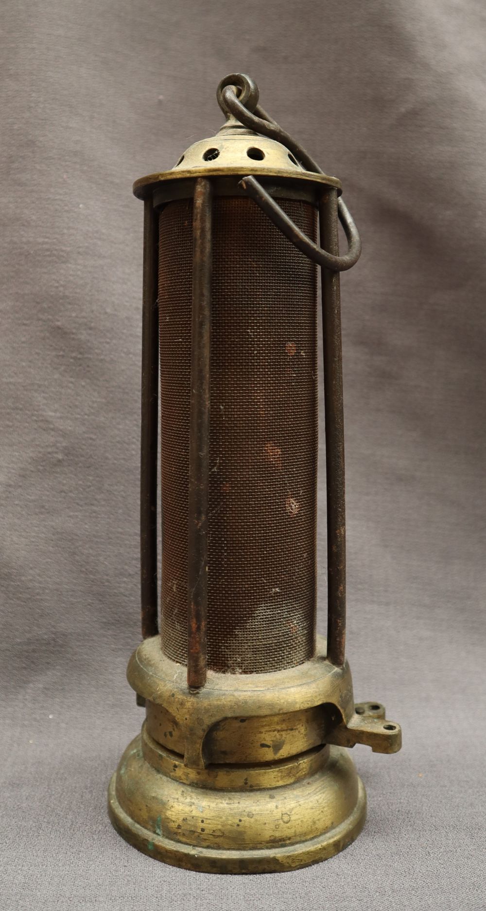 A brass Davy Miners lamp with a domed brass top and mesh screen, with glass interior,
