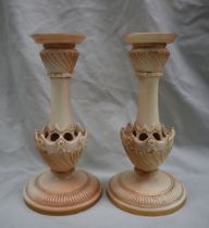 A pair of Royal Worcester porcelain candlesticks with a flared sconce and tapering column with a