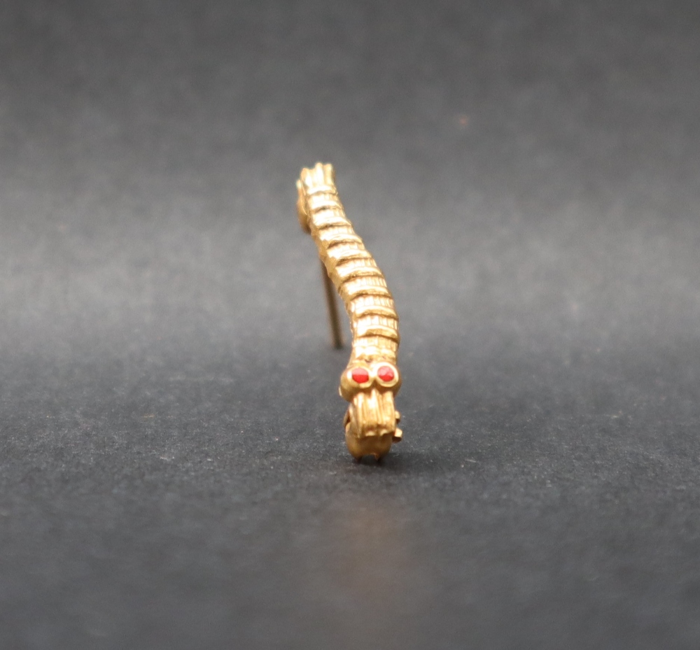 A yellow metal Caterpillar Club pin badge,