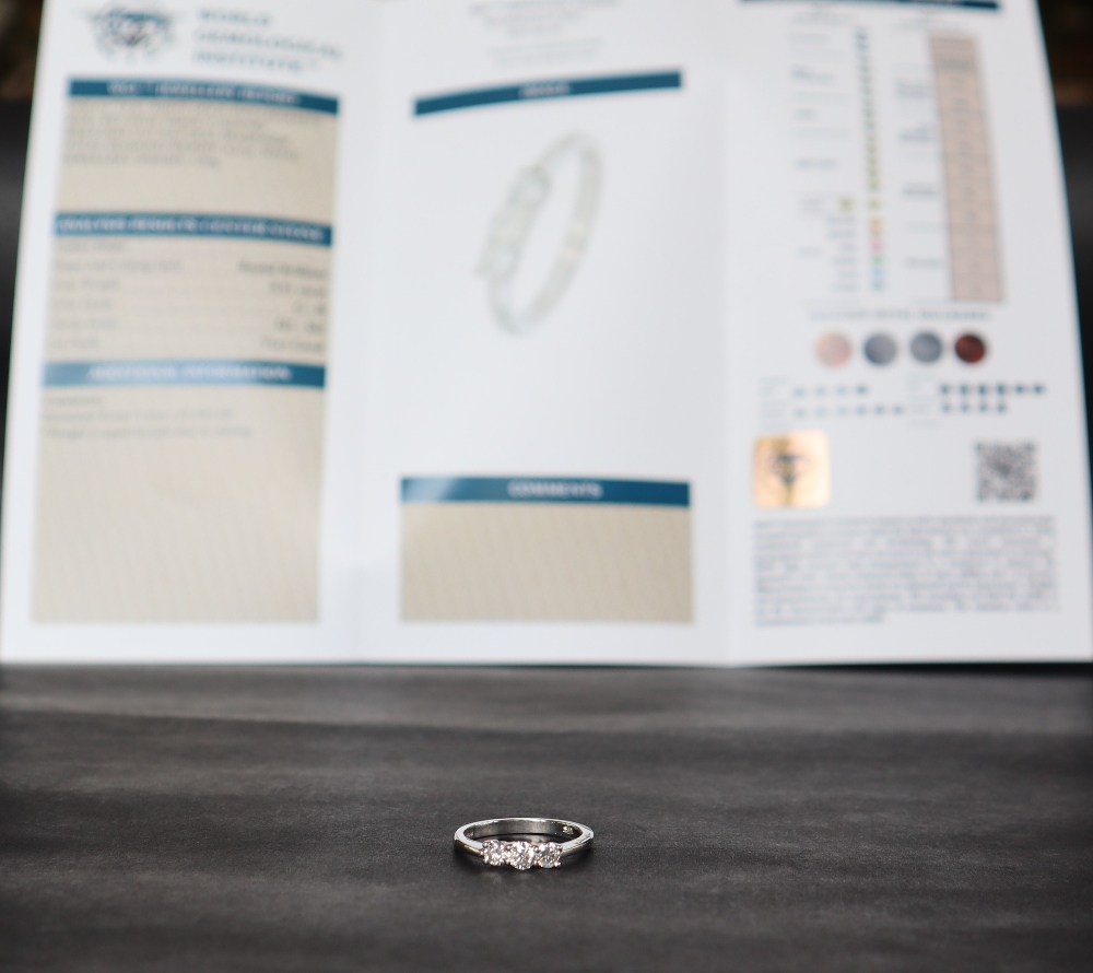An 18ct white gold three stone diamond ring with graduated round brilliant cut diamonds totalling - Bild 3 aus 8