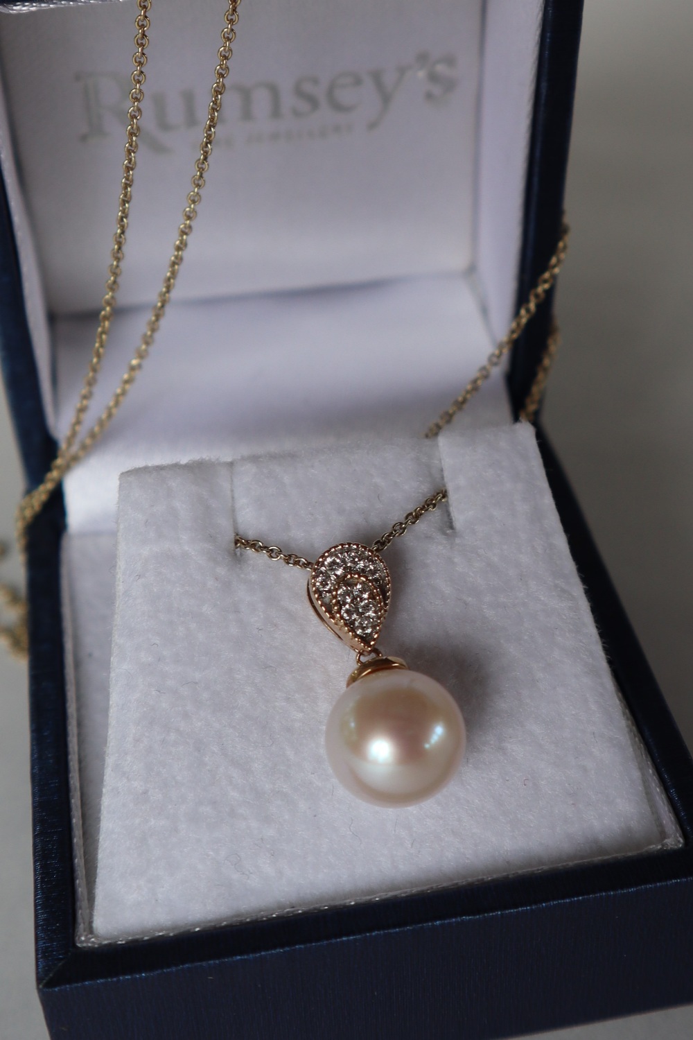 A 9ct yellow gold cultured pearl and diamond inverted pear-shape pendant and chain,