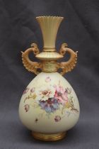 A Royal Worcester porcelain twin handled vase with a flared neck and scrolling handles,