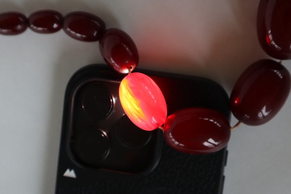 A string of cherry amber / bakelite beads, - Image 3 of 17