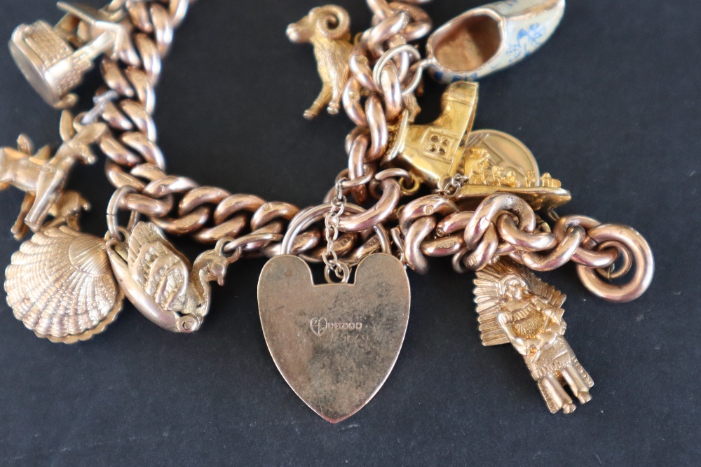 A 9ct yellow gold charm bracelet set with numerous charms including a St Christopher, Red Indian, - Image 6 of 6
