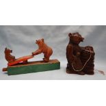 A Black Forest bear childrens toy with a mother and cub on a seesaw together with a bear carving