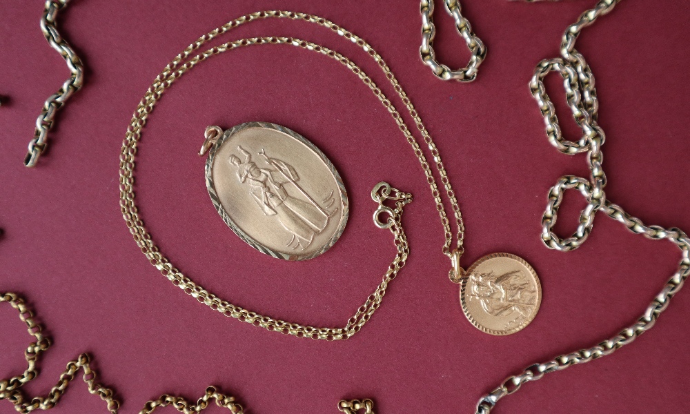 A 9ct gold St Christopher pendant together with another 9ct gold pendant and two 9ct gold chains