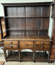 An 18th century South Wales oak dresser, the moulded cornice above two shelves and a planked back,