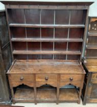 An 18th century Welsh oak dresser with a moulded cornice above three shelves and a planked back,