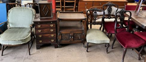 An Ercol elbow chair together with an oak smokers cabinet, a small chest of drawers,