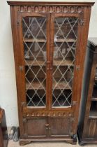 A 20th century oak bookcase with a pair of leaded glazed doors on bracket feet