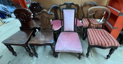 Three Victorian mahogany hall chairs together with a pair of Victorian balloon back dining chairs