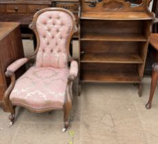 A Victorian walnut framed spoonback nursing chair together with a bookcase