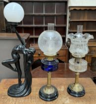 A Victorian oil lamp with a faceted blue glass reservoir on a brass column and spreading base