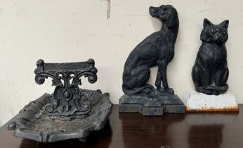 A cast iron door stop in the form of a black cat together with another of a hound and a cast iron