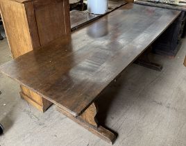 An oak refectory table with a planked rectangular top on shaped ends with stretchers,