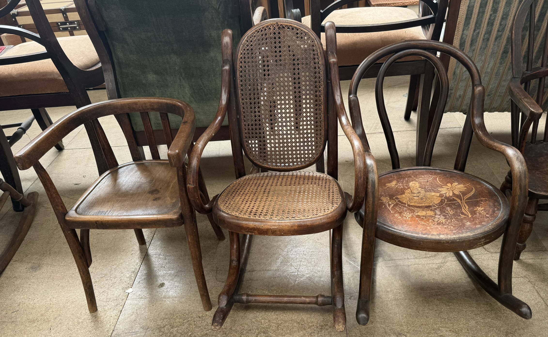 A child's bentwood rocking chair with Dutch child figure to the seat together with another child's