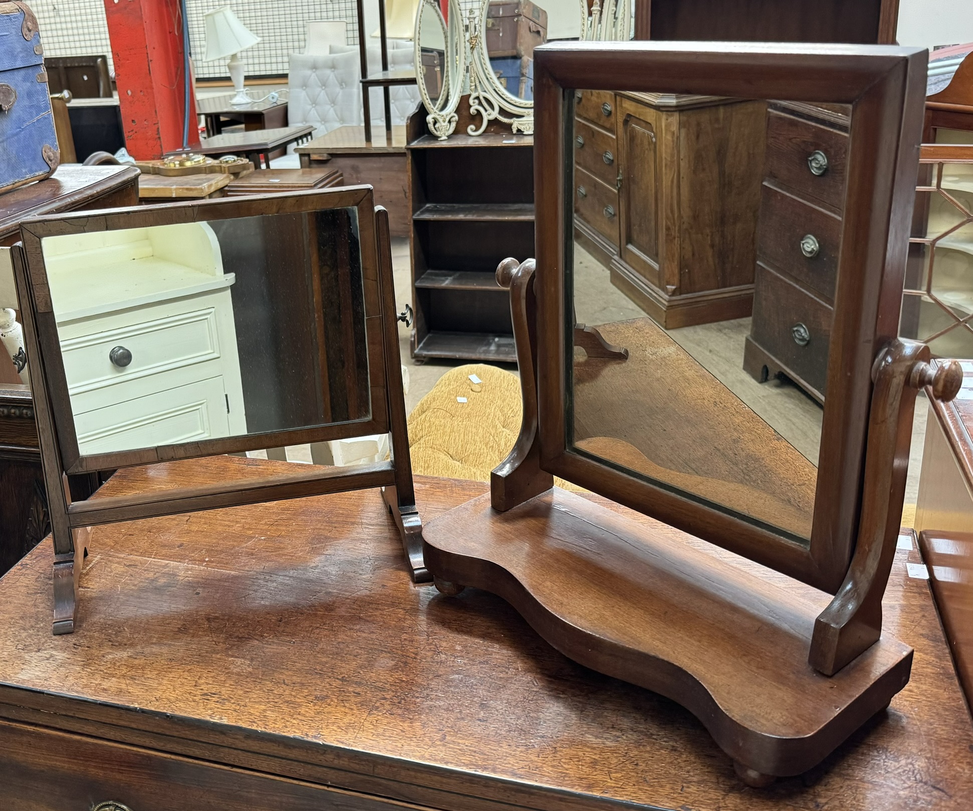 A Victorian mahogany toilet mirror with a rectangular plate above a shaped front on bun feet