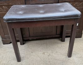 A piano stool with a pad upholstered top and four square legs