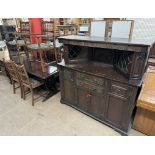 A 20th century dark oak dining suite comprising a refectory table,