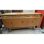 A G-Plan teak sideboard with three drawers and four cupboards on tapering legs,