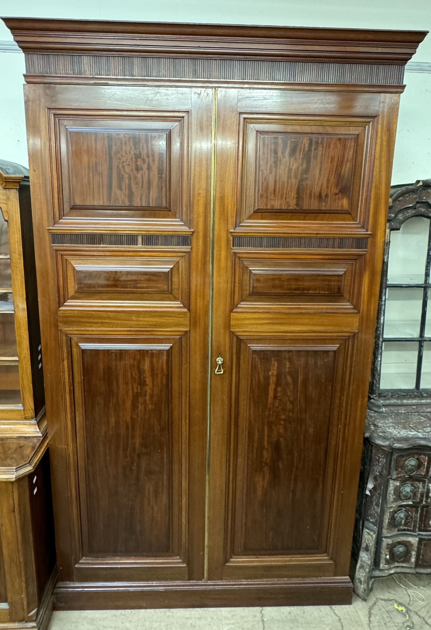 A 19th century mahogany armoire with a moulded cornice and a pair of panelled doors on a plinth