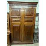 A 19th century mahogany armoire with a moulded cornice and a pair of panelled doors on a plinth